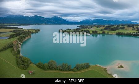 Vue par drone du lac de Forggen sous des nuages dramatiques dans les contreforts des Alpes bavarois. Banque D'Images