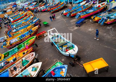 De petits bateaux de pêche sont alignés dans un chantier naval à Caleta Portales, un port de pêche artisanal à Valparaíso, au Chili. Banque D'Images