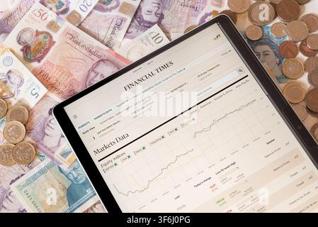 Site web FT Financial Times avec des billets et pièces en livres sterling en arrière-plan Banque D'Images