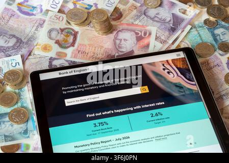 Site web de la BoE Bank of England avec des billets et pièces en livres sterling en arrière-plan Banque D'Images