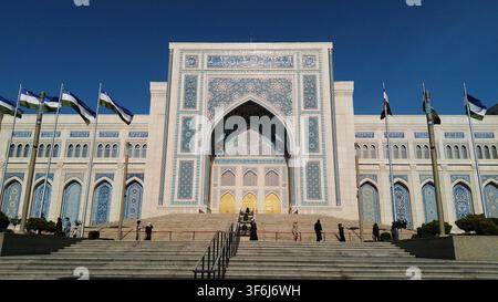 Tachkent, Ouzbékistan - 18 avril 2026 - Grand bâtiment avec des travaux de tuiles complexes et des mâts de drapeau devant, symbolisant le patrimoine culturel et religieux. Banque D'Images