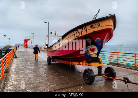Un petit bateau de pêche est transporté sur un chariot à bateaux à Caleta Portales, un port de pêche artisanal à Valparaíso, au Chili. Banque D'Images