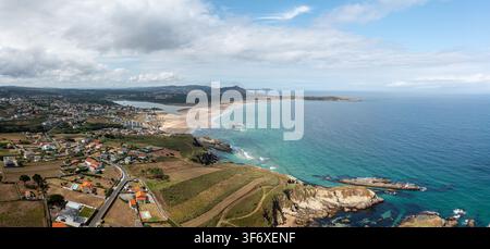 Vue aérienne de Praia de Valdovino avec sa vaste plage de sable, ses eaux turquoise de l'Atlantique, sa côte rocheuse et le paysage rural environnant à Valdo Banque D'Images