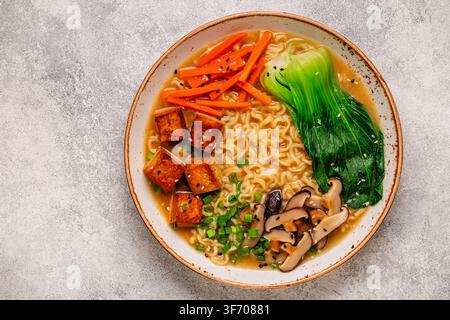 Soupe miso ramen aux nouilles servie avec du tofu, du bok choy, des carottes et des champignons dans un bol. Banque D'Images
