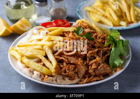Vue de dessus d'une assiette de kebab Doner turc traditionnel au poulet avec frites et salade ou Gyros grec Banque D'Images