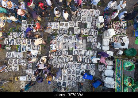 Vue aérienne d'un marché de poissons animé avec des travailleurs et des commerçants triant des prises fraîches dans des boîtes en polystyrène blanc au port affairé de Chattogram, Chittagong Banque D'Images