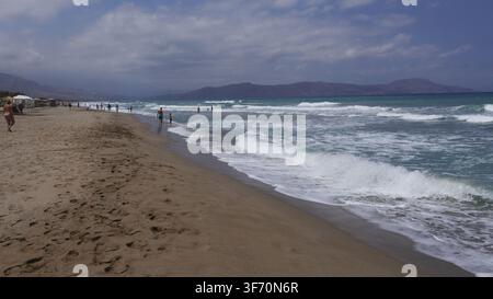 Vue en contre-plongée des vagues de l'océan se brisant sur la plage de sable d'Episkopi sous un ciel nuageux à Rethymno, Crète, Grèce. Banque D'Images