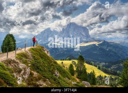 Femme avec un sac à dos debout au bord de la falaise contemplant les montagnes Banque D'Images