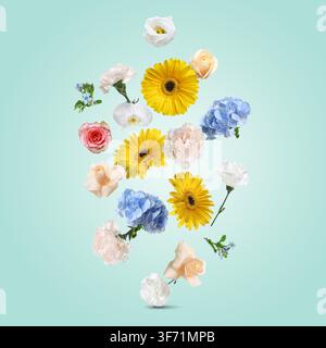 Fleurs vives volant dans l'air sur un fond turquoise Banque D'Images