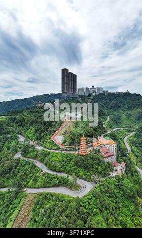 Vue aérienne du resort de Genting Highlands avec le temple des grottes de Chin Swee, des routes sinueuses et des immeubles de grande hauteur entourés par une forêt tropicale luxuriante dans Banque D'Images