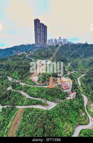 Vue aérienne du complexe touristique de Genting Highlands avec des gratte-ciel et le temple des grottes de Chin Swee niché parmi des collines verdoyantes et des routes sinueuses à Gentin Banque D'Images
