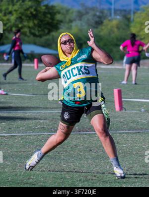 Mai 2023 : Un joueur de flag football portant un maillot à capuche se prépare à lancer le ballon sur un terrain en herbe pendant une partie. Banque D'Images