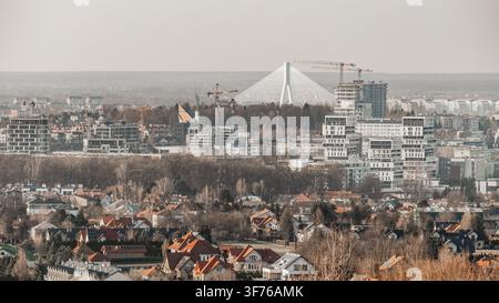 Paysage urbain avec des bâtiments modernes et un pont à câbles vu depuis une colline éloignée Banque D'Images