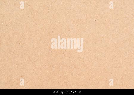 Un fond avec la texture naturelle du papier kraft beige fabriqué à partir de fibres recyclées. Banque D'Images