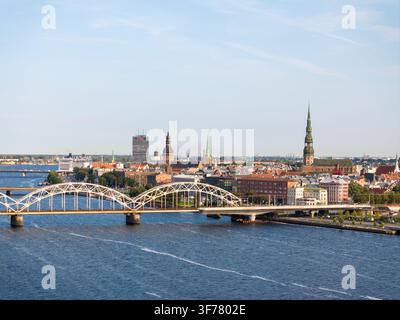 Riga, Lettonie - 10 juillet 2026 : Vue panoramique sur la skyline de la vieille ville de Riga, la Daugava et le pont ferroviaire par une journée d'été ensoleillée. Banque D'Images