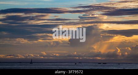 Une vue pittoresque à l'heure dorée sur les eaux calmes du golfe d'Amérique (golfe du Mexique) à Destin, en Floride. De grands nuages dramatiques remplissent le ciel du coucher de soleil Banque D'Images