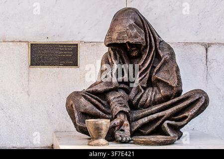 Italie Ligurie Gênes - Basilique dell'Annunziata - La sculpture extérieure de Timothy Schmalz à la Basilique della Santissima Annunziata del Vastato représente un mendiant avec le signe de la croix sur sa main tendue. Inaugurée le 18 novembre 2023, l'œuvre traduit visuellement le verset évangélique de Matthieu 25:40, incarnant l'appel à reconnaître le Christ chez les plus démunis et les plus vulnérables. Banque D'Images