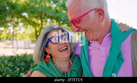 Couple de personnes âgées partageant un moment heureux en riant en plein air Banque D'Images