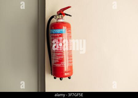 Extincteur suspendu au mur lumineux dans le bâtiment Banque D'Images