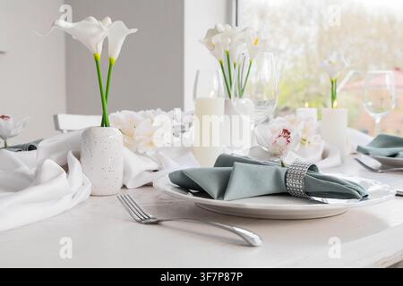 Élégante mise en table avec des callas blancs, des orchidées et des bougies pour une réception de mariage ou un événement spécial Banque D'Images