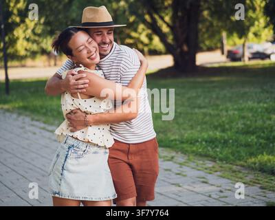 Couple passionné s'embrassant en se promenant dans le parc par une journée d'été ensoleillée. Banque D'Images