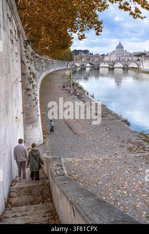 Automne sur le Tibre, vue vers le Ponte Sant'Angelo et la Basilique Saint-Pierre depuis le chemin de halage le long du Tibre au centre de Rome, Italie. Banque D'Images