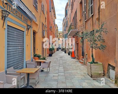 Une rue pavée étroite et déserte bordée de maisons aux couleurs pastel à Bastia, Corse, France Banque D'Images