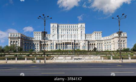 Palais du Parlement à Bucarest avec un ciel bleu clair et des espaces verts visibles devant Banque D'Images