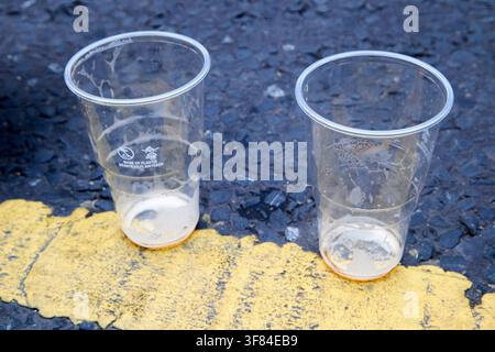 deux verres à pint en plastique vides posés sur la ligne jaune de la route à la Fleadh Cheoil na hEireann à Belfast en Irlande du Nord le 8 août 2026 Banque D'Images