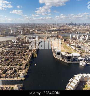 Une vue aérienne de l'Isle of Dogs, Londres, mettant en valeur le Millwall Dock et la densité urbaine en évolution menant vers la ligne d'horizon de la ville. Banque D'Images
