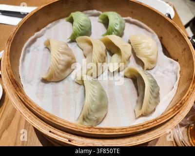 Dumplings cuits à la vapeur dans un cuiseur en bambou représentant un authentique dim sum chinois et une cuisine asiatique. Banque D'Images