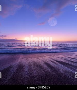 Une pleine lune se lève au-dessus d'une scène océanique au coucher de soleil colorée Vertical Banque D'Images