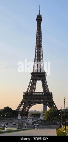 La majestueuse tour Eiffel se dressant fièrement contre un ciel clair du soir pendant l'heure dorée à Paris. Banque D'Images