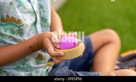 Enfant tenant un jouet anti-stress en forme de boulette violette en gros plan Banque D'Images