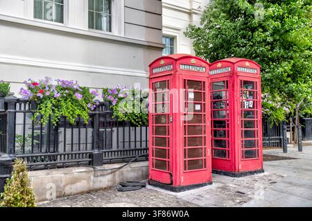 Cabinets téléphoniques rouges traditionnels dans une rue de Knightsbridge, Londres, Angleterre. Banque D'Images