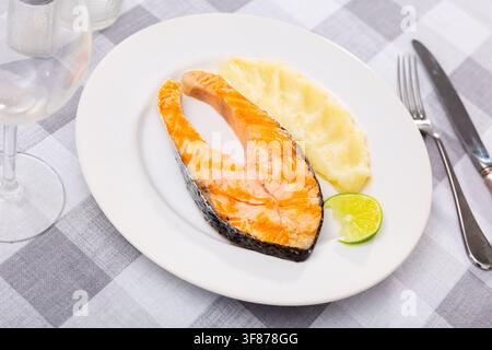 Steak de saumon au four et purée de pommes de terre servie avec du citron vert Banque D'Images