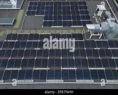Vue aérienne d'un champ de panneaux solaires montés en rangées sur un toit plat commercial, concept détaillé d'énergie renouvelable et d'installation photovoltaïque. Banque D'Images
