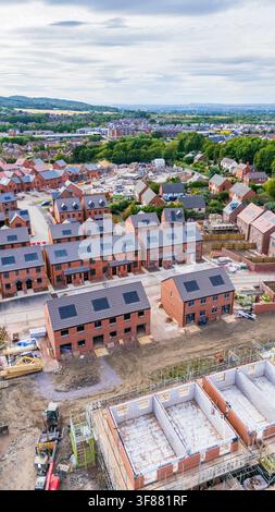 Une image par drone d'un nouveau lotissement avec des maisons à différents stades de construction, dont certaines dotées de panneaux solaires sur le toit de maisons durables Banque D'Images