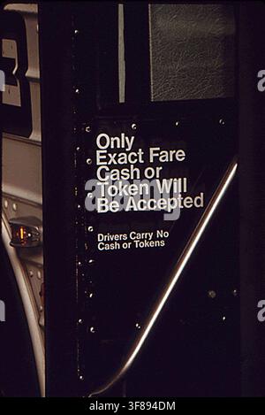 Un panneau dans un bus de la Metropolitan Atlanta Rapid Transit Authority (MARTA) à Atlanta, Géorgie, indiquant que le conducteur n'accepte que la monnaie exacte ou un ticket, pendant une période d'augmentation du nombre de passagers en 1974. Banque D'Images