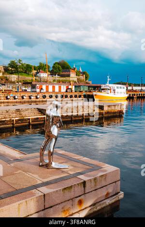 Oslo, Norvège – 15 mai 2026 : Dykkaren, une sculpture en argent représentant un plongeur par Ola Enstad, surplombe le port d’Oslo depuis Radhusbrygge, avec un bateau amarré et Akershu Banque D'Images