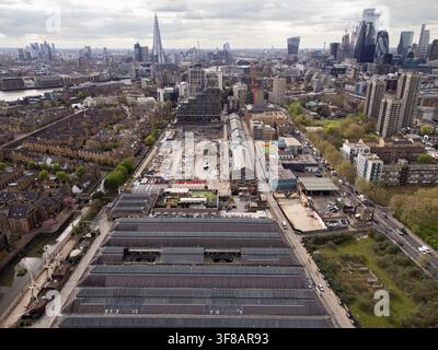 Vue aérienne d'un grand chantier de construction au Tobacco Dock, Wapping, reflétant le développement urbain devant l'horizon emblématique de Londres. Banque D'Images