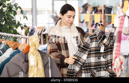Femme arménienne choisissant des vêtements d'extérieur dans le magasin Banque D'Images