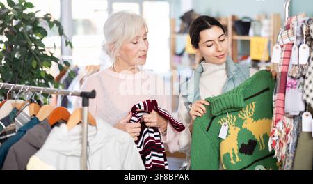 Mère âgée et sa fille adulte choisissent ensemble pull dans le magasin de vêtements Banque D'Images