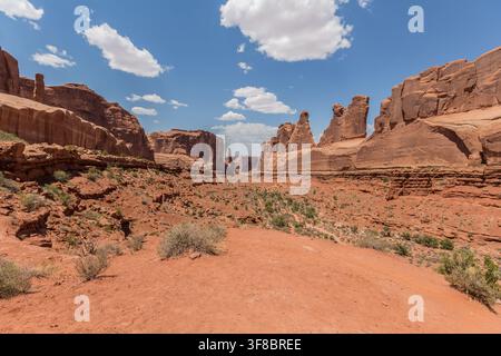 Vue des formations rocheuses rouges dramatiques et du paysage désertique du parc national des Arches sous un ciel bleu éclatant dans le comté de Grand, Utah, États-Unis. Banque D'Images