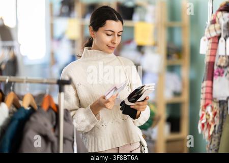 Fille choisit des chaussettes chaudes pour l'hiver dans le magasin de vêtements Banque D'Images