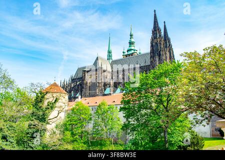 Les flèches de la cathédrale Saint-Víte émergent au-dessus du château de Prague parmi les arbres verts Banque D'Images