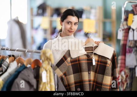 Femme arménienne choisissant des vêtements d'extérieur dans le magasin Banque D'Images