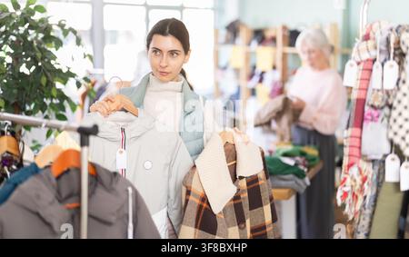 Femme arménienne choisissant des vêtements d'extérieur dans le magasin Banque D'Images