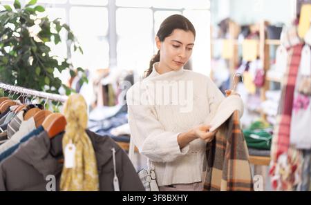 Femme arménienne choisissant des vêtements d'extérieur dans le magasin Banque D'Images