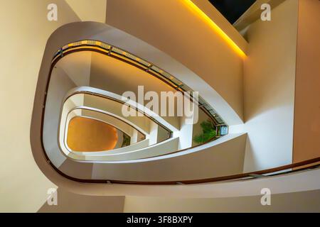 Vue de l'élégante escalier en colimaçon à l'intérieur du The Peninsula Tokyo, présentant des courbes architecturales modernes, un éclairage chaleureux et un design minimaliste à Chiyod Banque D'Images